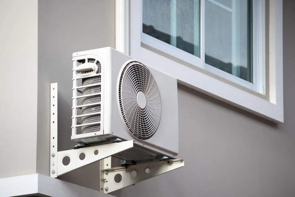 Condensadora de ar-condicionado split fixada em suporte na parede externa